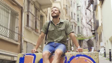 Young-man-is-sitting-on-the-street.