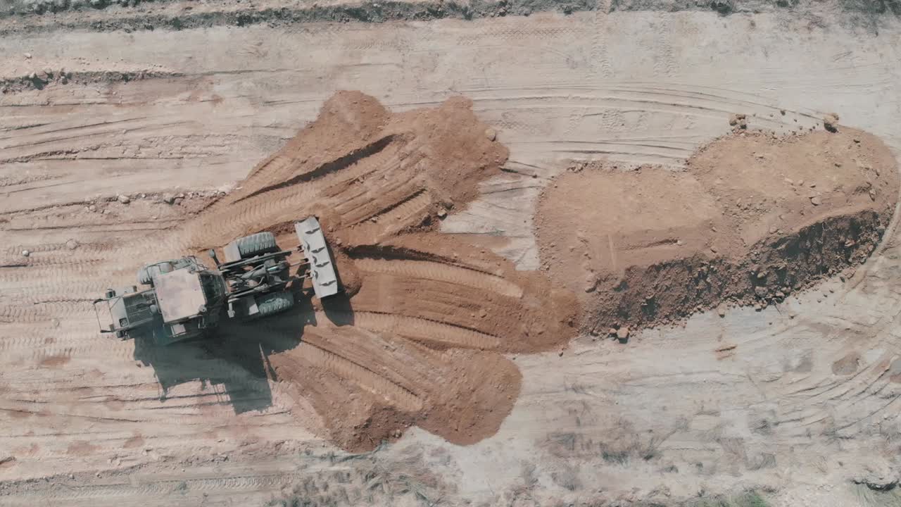 Luftfoto ovenfra af en gravemaskine, der planerer jorden i Pakistan.