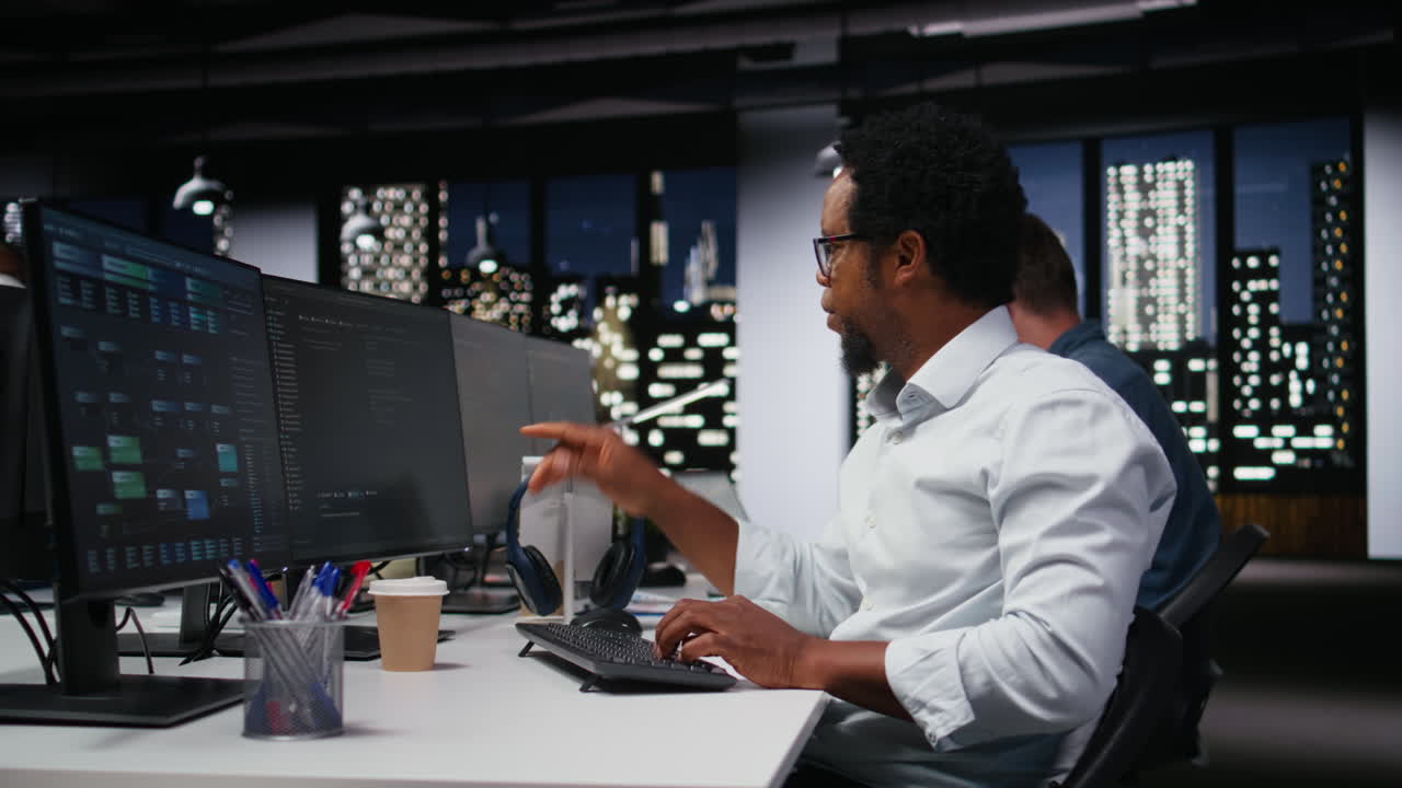 African American Programmer Working on Computer in Modern Office at Night