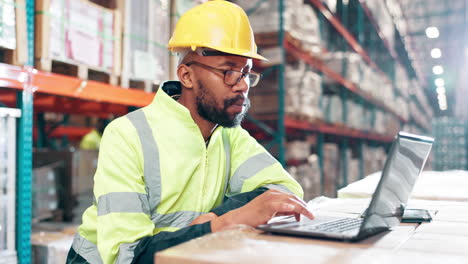 warehouse worker with laptop inspecting inventory