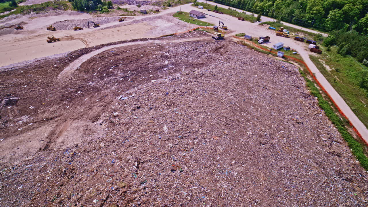 Drone shot panning around landfill dump area with birds flying all around
