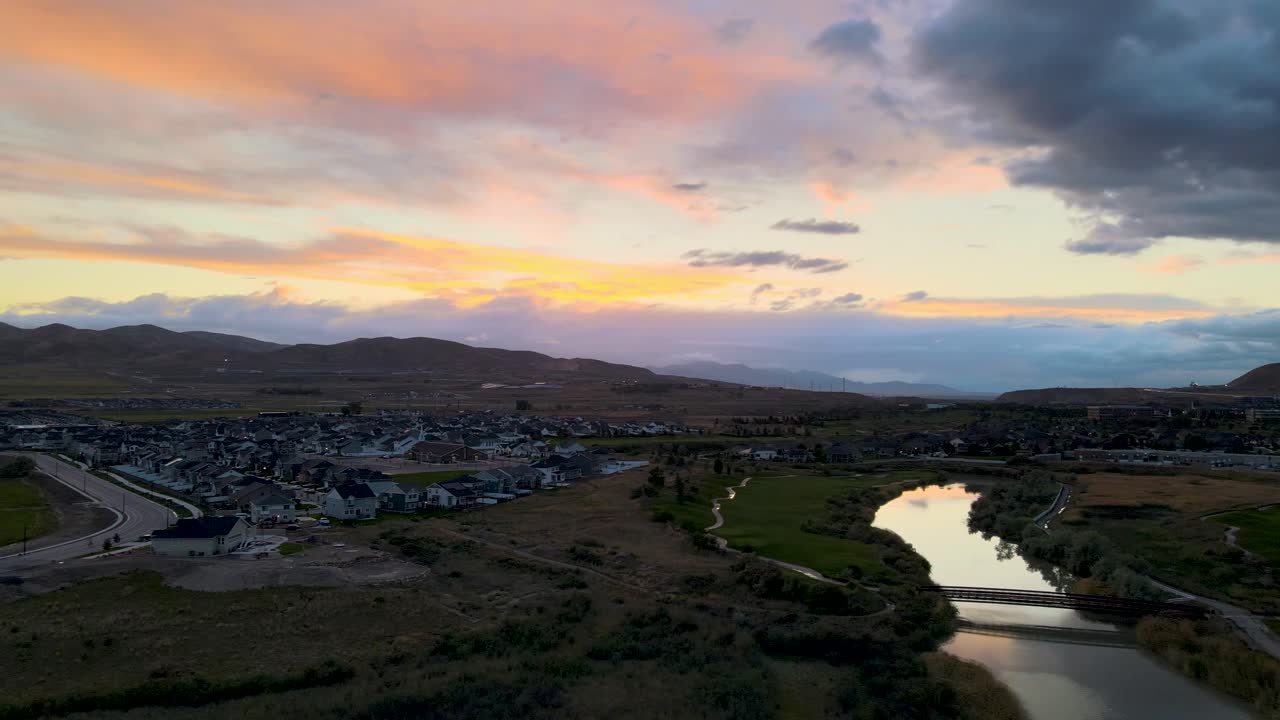 río tranquilo con la colorida puesta de sol reflejándose en la superficie del agua - vista aérea deslizante