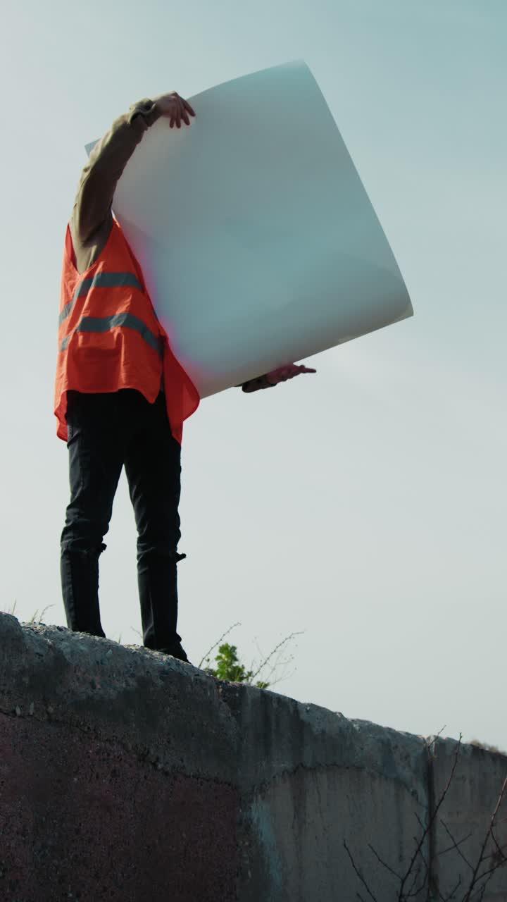 Architect Up On A Wall At The Outdoor Construction Site Looking At The Project
