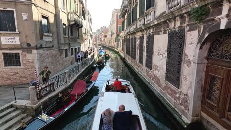 gondolas and boats navigate a narrow venice canal