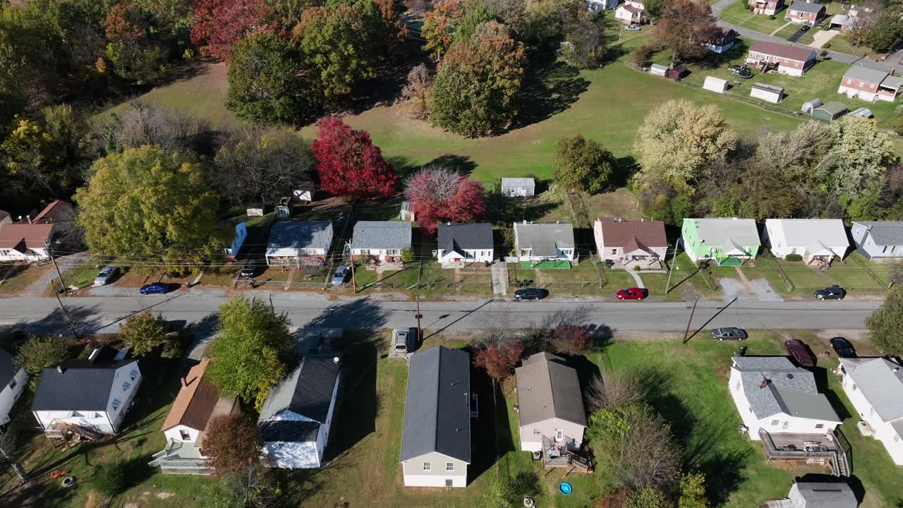 Aerial tilt up wide shot of American suburb residential area with typical houses and homes. Sunny da. With blue sky in Virginia. Blue ridge mountains and colored trees in USA. Establishing shot