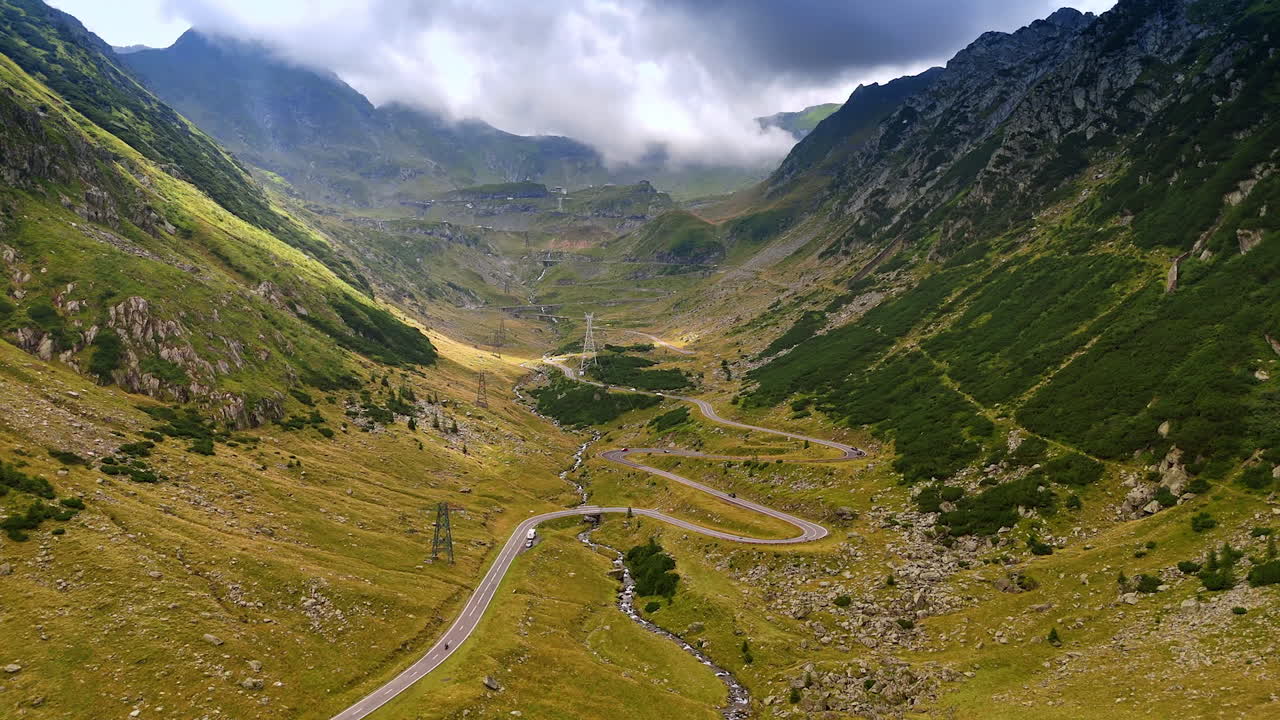 Transfagarash highway in the valley among the mountains. Aerial perspective on the road wriggling in the Carpathian Mountains, Romania