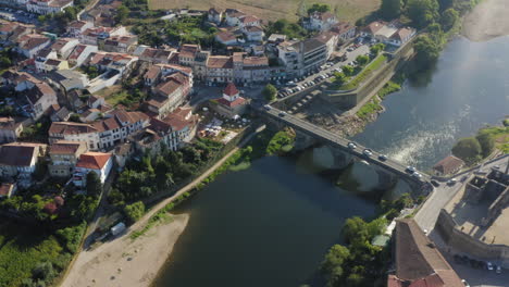 barcelinhos y barcelos riverside vista atravesada por el puente medieval toma aérea - órbita