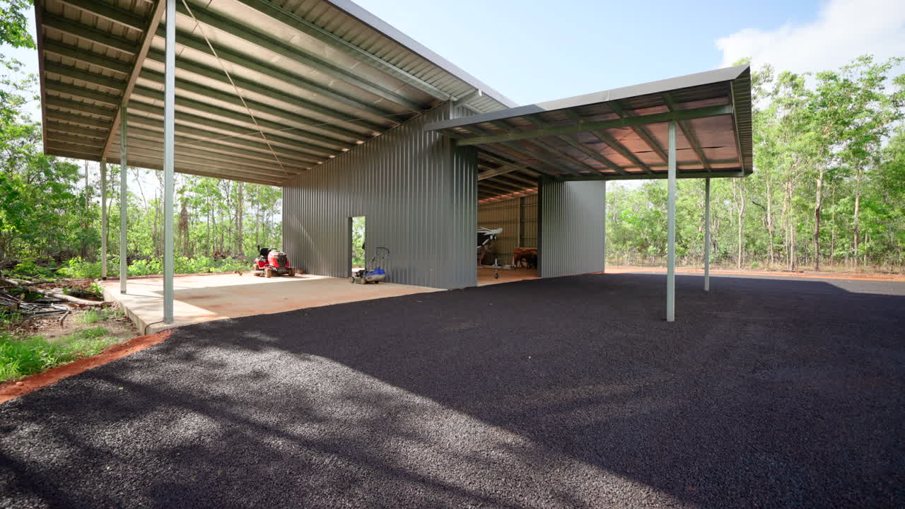 gran cobertizo con suelo de hormigón y entrada de bituminos