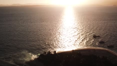 volando sobre la isla fiyiana al amanecer con barcos en el océano