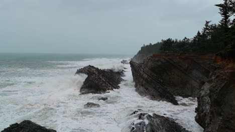 strong waves crash on rocks at shore acres state park at oregon coast