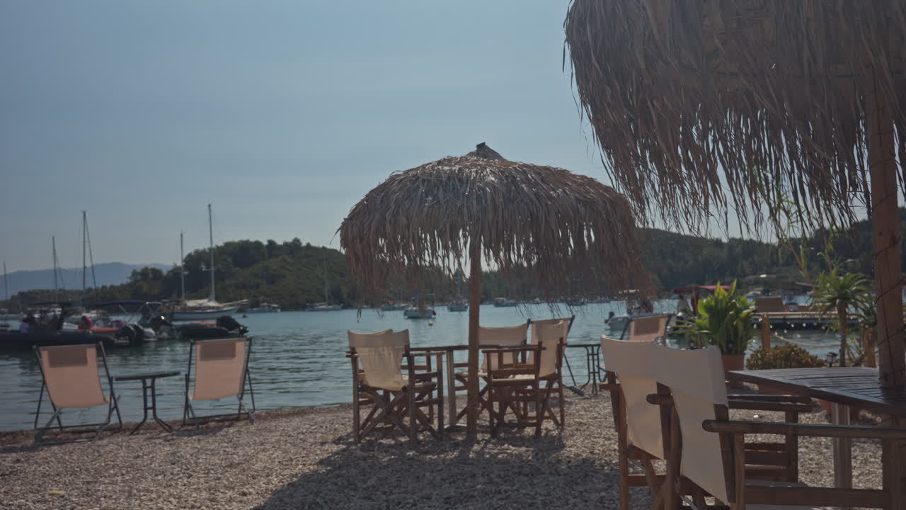 tables and chairs in a terrace bar by the harbour in nydri lefkada, greece