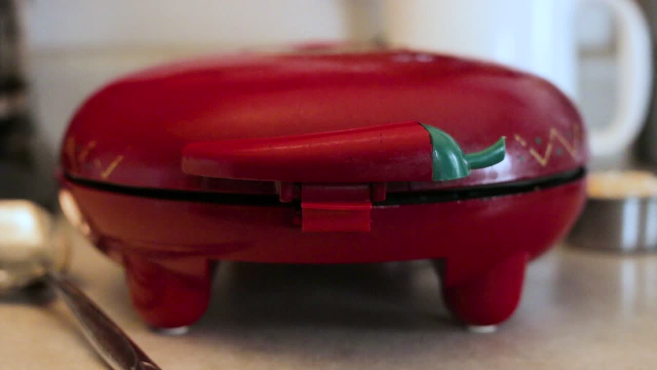 1080p still shot of quesadilla maker lid closing.