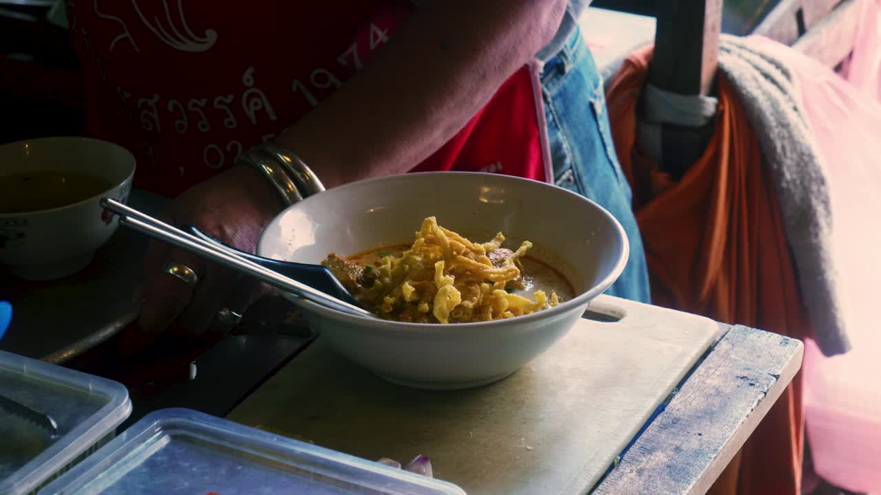 태국 의 한 식당 에서 카오 소이 라는 전통 태국 음식 의 요리 를 준비 하는 태국 의 요리사 의 4k 영화적 요리 영상