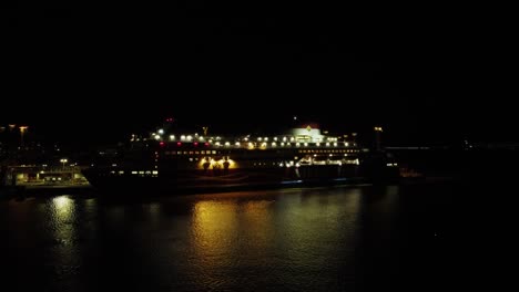Ein-Riesiges-Kreuzfahrtschiff-Am-Helsinki-Dock-Spiegelt-Sich-Im-Nächtlichen-Hafenwasser