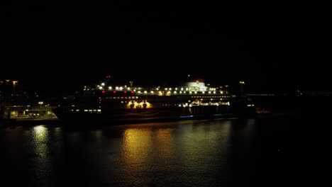 huge cruiseship at helsinki dock reflects onto night harbour water