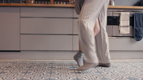 Una-Pareja-Joven-Feliz-E-Irreconocible-Recién-Casada-Bailando-Escuchando-Música-En-La-Cocina-Usando-Pijamas-Por-La-Mañana-En-Casa-Enamorada