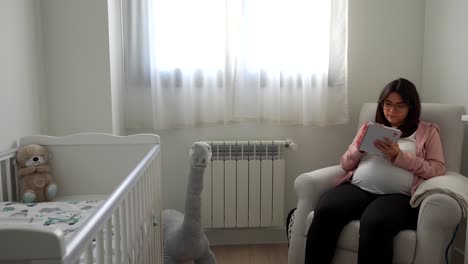 pregnant woman writing notes on what is pending for the future baby