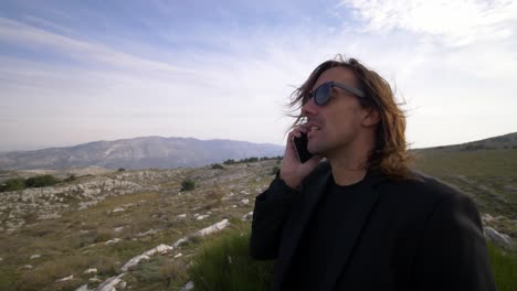 un hombre usando su teléfono en la montaña