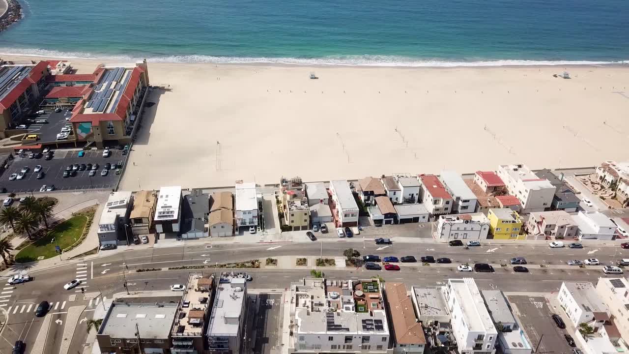 Aerial view of Redondo Beach, Los Angeles. Bright sand, calm Pacific waves and colorful beachfront houses in California. Coastal vibes and peaceful town in USA
