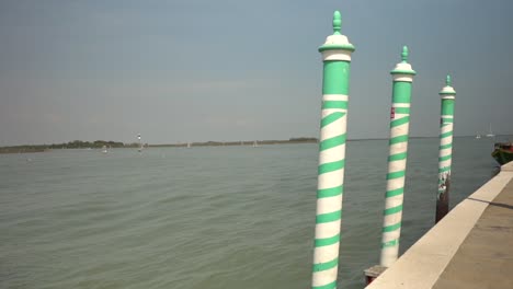 green and white striped posts on the dock of a pier mark the area for boats