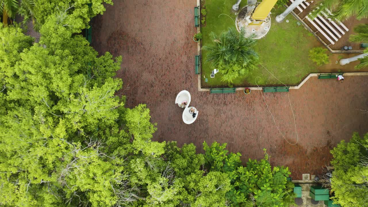 pareja joven sentada en sillas de besos gigantes famosas de merida, la capital de yucatan