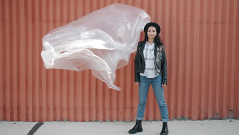 stylish woman in urban setting with plastic sheet