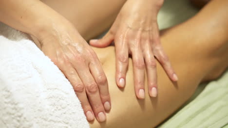 masseuse working in a spa, female hands giving a leg massage