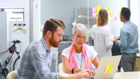 Executives-discussing-over-laptop-on-table-4k