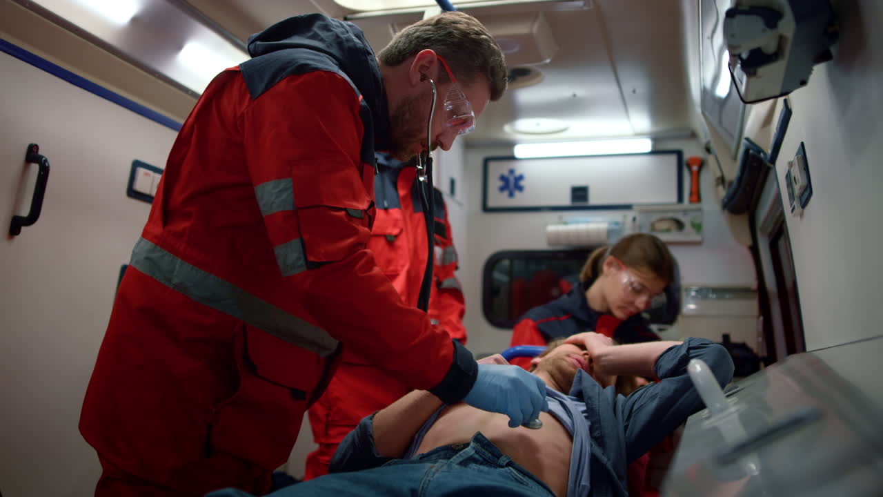 여러 민족의 구급대원들이 사람에게 응급 처치를 하고 있습니다.