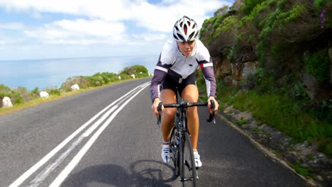 female cyclist cycling on a countryside road 4k