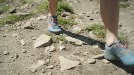 man walking on rocks in shorts and wearing low cut hiking shoes