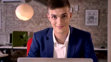 young sweet businessman is watching in laptop, watching at camera, communication concept, business concept