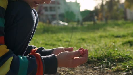 vista lateral de cerca de un niño caucásico con polvo en las manos