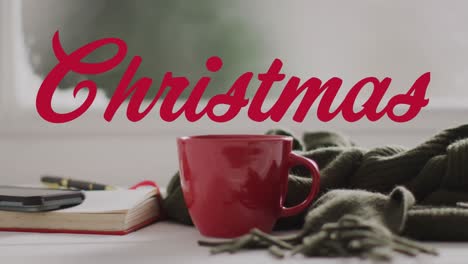 animación de saludos de navidad texto sobre taza roja y decoraciones de navidad.