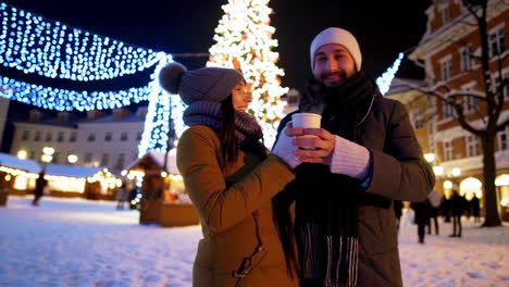 christmas market at night with people and hot drinks