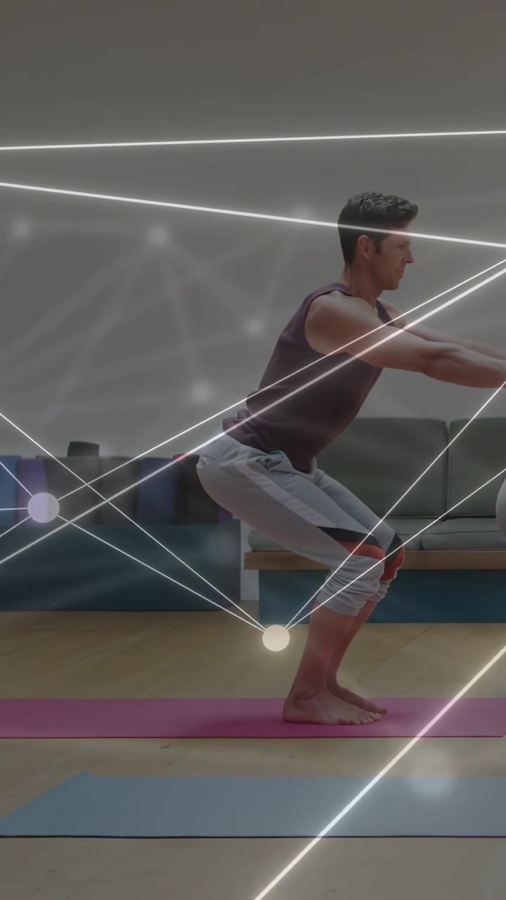 Vertical video: Adult man initiating squat on pink mat, glowing network guiding balance for fitness