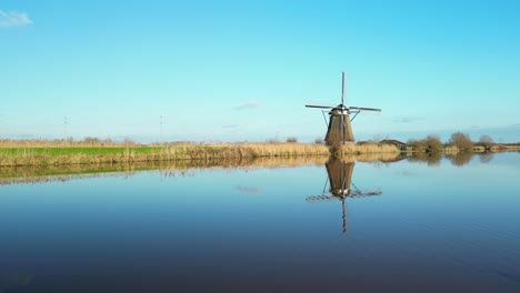 beautiful reflection of a traditional windmil at kinderdijk on a bright autumn day