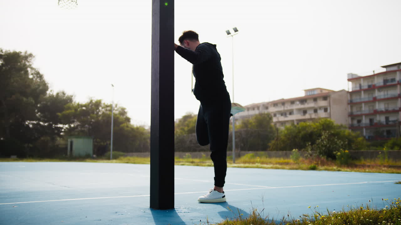 Basketball Player Prepares for the Match at the Park by Stretching