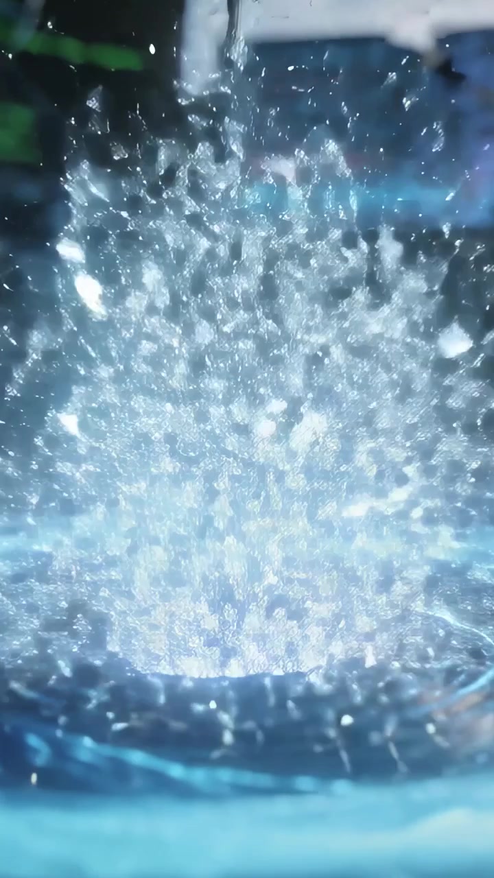 Video verticale: Vortice luminoso che trascina un frammento di diamante incrinato verso il basso in laboratorio, causando un'esplosione luminosa.