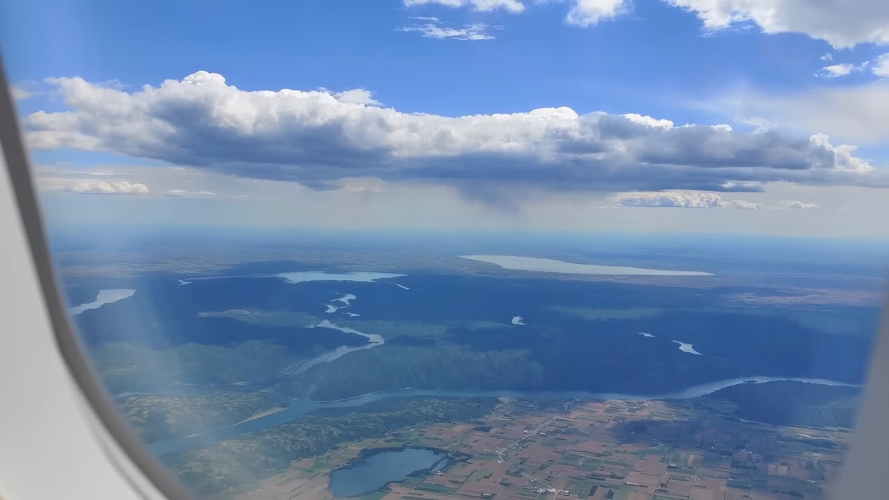 Luftudsigt over landskab med søer og marker fra et flyvindue