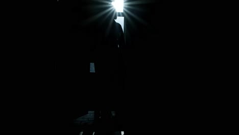 man walks along a dark long corridor. abandoned building, dark corridor, dark silhouette of a man, light in the doorway, ruins, broken windows, rust, unfinished