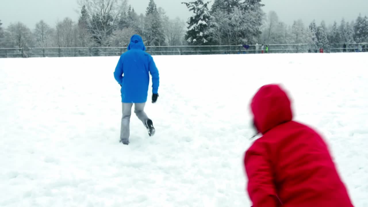 pareja jugando con bola de nieve