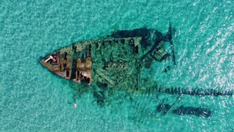 Old-rust-shipwreck-in-Turquoise-sea-from-above