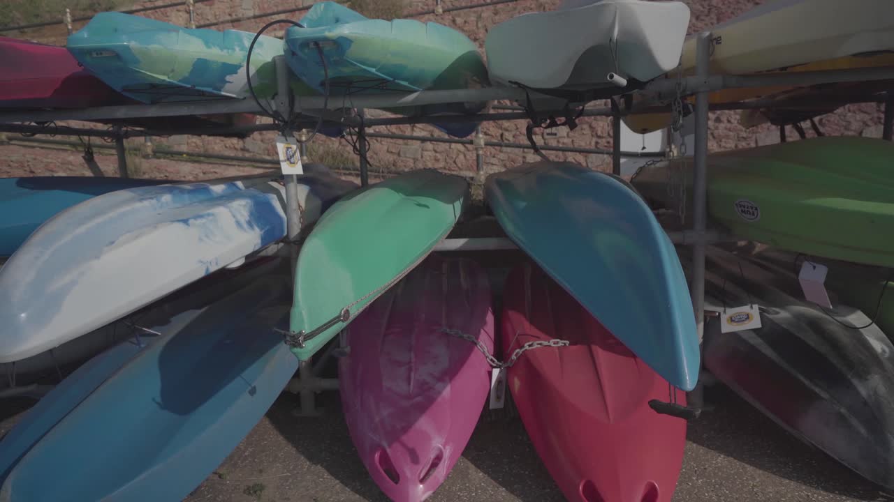 diferentes tamaños y tipos de kayaks rígidos para alquilar almacenados en huntstanton beach en inglaterra