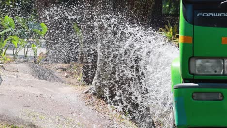 truck sprays water on roadside vegetation