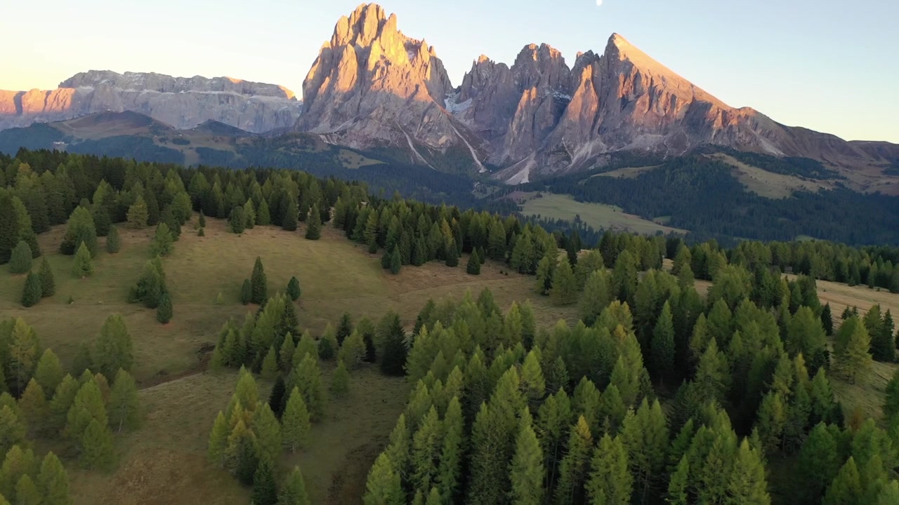 Spektakulær højvinkel droneudsigt over de ikoniske Tre Cime di Lavaredo i Italien. Viser de majestætiske tre kalkstensbjergtinder, der tårner sig op over barskt alpint terræn og vandrestier.