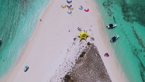 drone descends tilting up to reveal sandy isthmus and kite surfing camp, cayo de agua