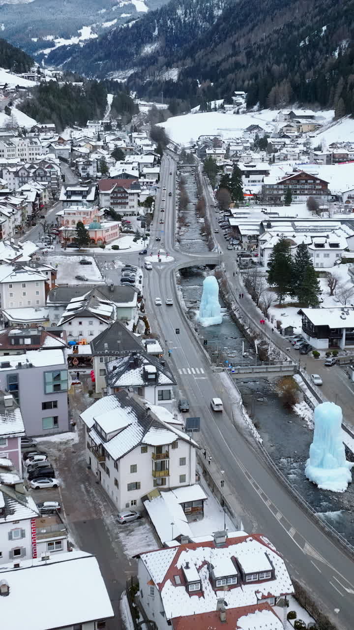 Aerial drone view of the Ortisei town covered in snow, within the Dolomites, in northern Italy. Vertical