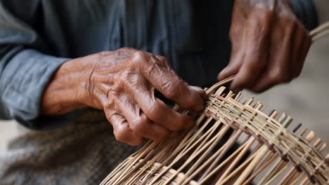 close-up of hands weaving a bamboo craft