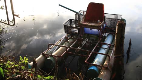 Ein-Behelfsmäßiges-Floß-Am-Ufer-Eines-Sees-Mit-Wolken,-Die-Sich-Im-Wasser-Spiegeln